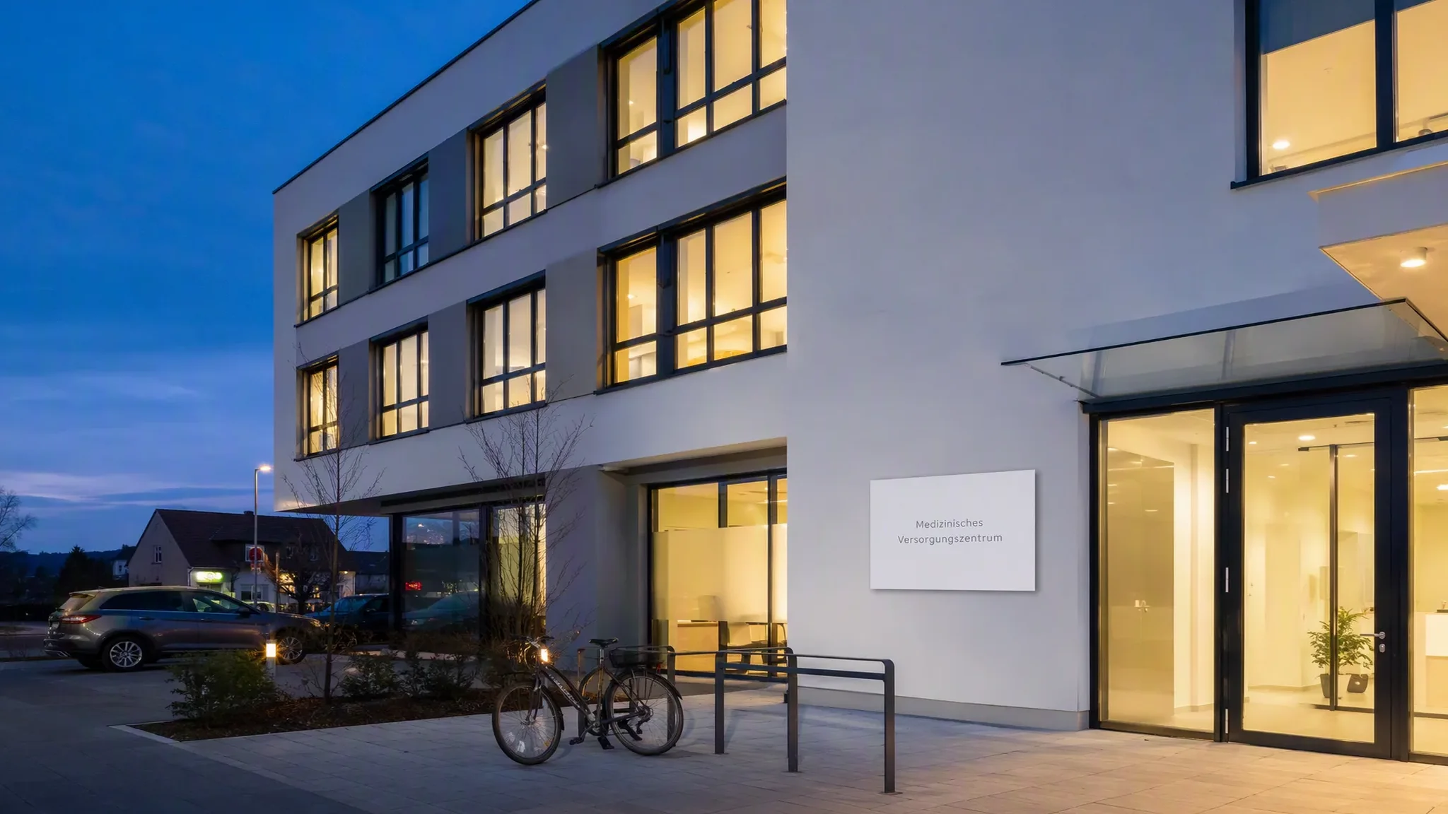Modernes deutsches Medizinisches Versorgungszentrum zur blauen Stunde – warmes Licht in den Fenstern